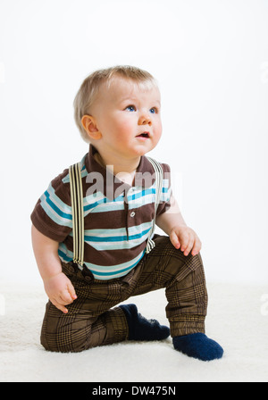 Baby Boy, weißer 16 Monate alt in gestreiften Hemd und Hosenträgern, Hintergrund Stockfoto