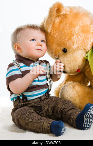 Baby Boy, weißer 16 Monate alt in gestreiften Hemd und Hosenträgern, Hintergrund Stockfoto