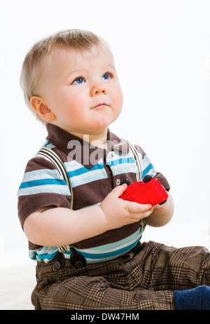 Baby Boy, weißer 16 Monate alt in gestreiften Hemd und Hosenträgern, Hintergrund Stockfoto