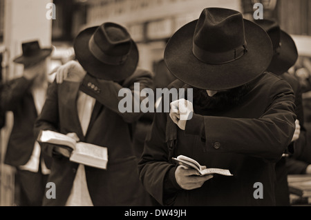 Religiöse jüdische junge Männer bedecken ihre Augen während am Nachmittag Gebete Lubawitsch Hauptquartier in Crown Heights, Brooklyn, NYC Stockfoto