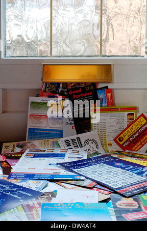 ein riesiger Haufen von Junk-Mails, die durch eine Haustür-Briefkasten gesteckt wurde Stockfoto