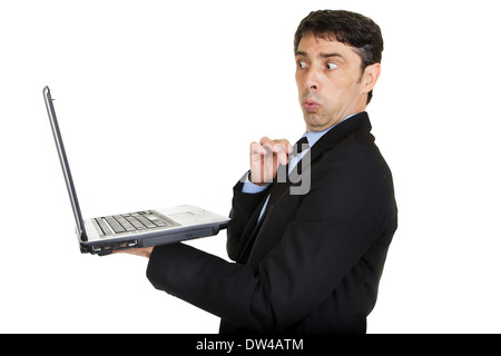 Suchen Sie verblüfft und beleidigt, als er auf seinem handheld Laptop-Bildschirm sucht Mann Stockfoto