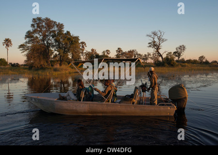 Segeln bei Sonnenuntergang auf einem Schnellboot im Wasser Safari Camp in Eagle Island Camp von Orient-Express, außerhalb des Moremi Game Orchesterprobe Stockfoto