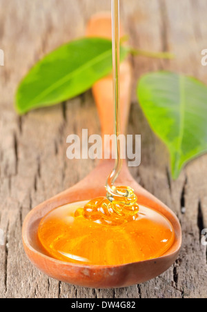 Tropft in einen hölzernen Löffel Honig Stockfoto