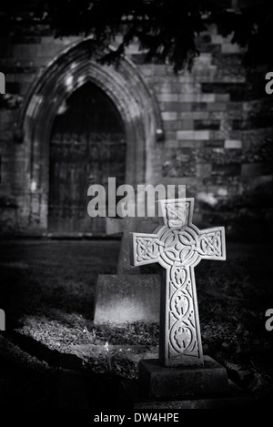 Keltisches Kreuz beleuchtet von der Sonne in Adderbury Kirchhof, Oxfordshire, England Stockfoto
