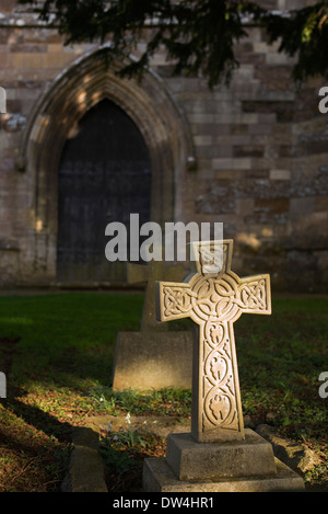 Keltisches Kreuz beleuchtet von der Sonne in Adderbury Kirchhof, Oxfordshire, England Stockfoto