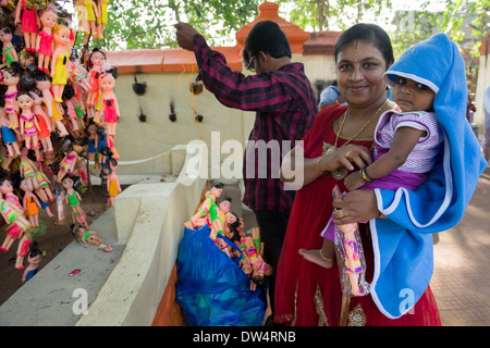 Paar binden Plastikpuppen an einen Baum am Janardhana Swamy Tempel zu danken für ihr Kind, Varkala, Kerala, Indien Stockfoto