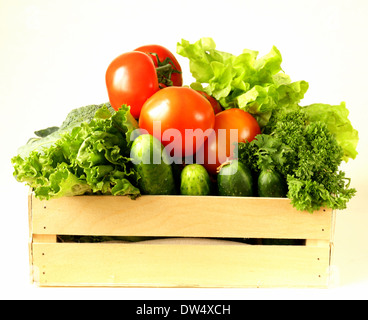 verschiedene Gemüse in einer Holzkiste (Tomaten, Gurken, Kopfsalat) Stockfoto
