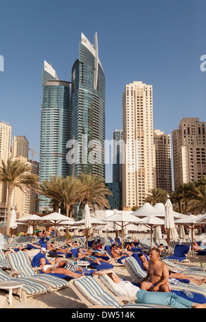 Massen von Touristen im Urlaub Sonnenbaden am Jumeirah Beach im Winter, Dubai, Vereinigte Arabische Emirate, Vereinigte Arabische Emirate, Naher Osten Stockfoto