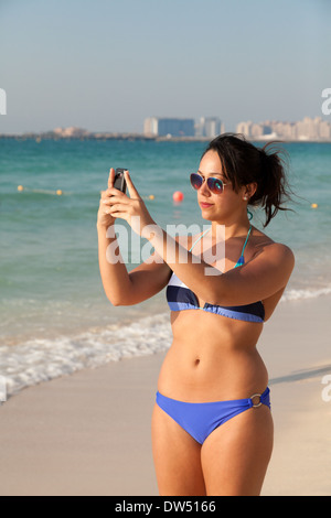 Junge Frau im Bikini fotografieren Selfie von sich selbst am Jumeirah Beach, Dubai Vereinigte Arabische Emirate VAE Naher Osten Stockfoto