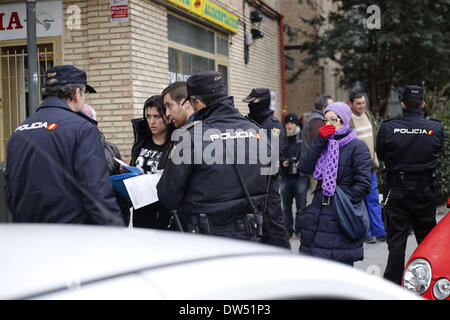 Madrid, Spanien. 27. Februar 2014. Carolina Salazar Fernandez, 23 Jahre alt, zweiter von links, begleitet von Recht auf Wohnraum Aktivisten argumentiert mit der Justizkommission und der Polizei, wie sie versuchen, ihre Vertreibung in Madrid, Spanien, Donnerstag, 27. Februar 2014 zu stoppen. Carolina Salazar Fernandez ist eine alleinerziehende Mutter von zwei Kindern: Jesus, 3 Jahre alt, und Abraham, 6 Jahre alt. Ihr einziges Einkommen, ist es ein Staat nutzen von 530 Euro ($ 723). Sie hat eine leere abgeschotteten Wohnung Besitz SAREB Bank im Februar 2013 besetzt. Sie versucht zu verhandeln, um eine niedrige geschützten Miete zahlen, seit ihr Einkommen ist nicht genug zu mieten ein Stockfoto