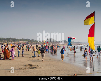Indien, Goa, Baga, indische Touristen am Strand Rettungsschwimmer zwischen sicheren Baden Fahnen Stockfoto