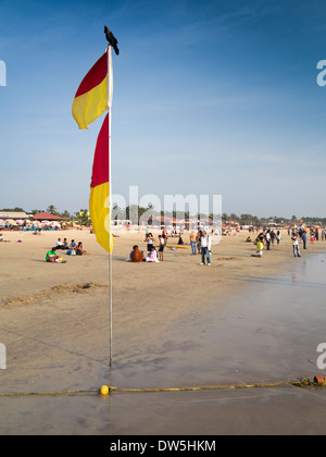 Indien, Goa, Baga, indische Touristen am Strand Rettungsschwimmer zwischen sicheren Baden Fahnen Stockfoto