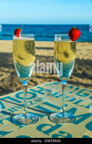 Zwei Gläser Sekt auf den Tisch mit Sandstrand und Meer im Hintergrund Stockfoto