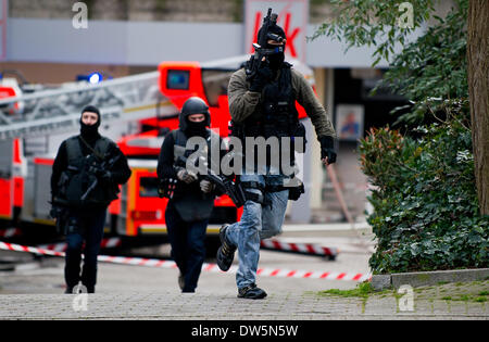 Düsseldorf, Deutschland. 28. Februar 2014. Polizisten mit Gewehren vor einer Anwaltskanzlei Gebäude in Erkrath laufen in der Nähe von Düsseldorf, 28. Februar 2014. Ein Angriff getötet, zwei Frauen. Foto: JAN-PHILIPP STROBEL/Dpa/Alamy Live News Stockfoto