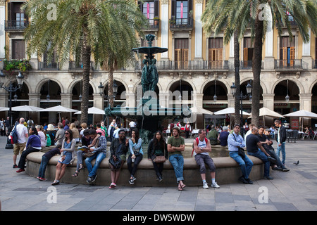 Spanien, Katalonien, Barcelona, Touristen saßen rund um den Brunnen im Placa Reial. Stockfoto