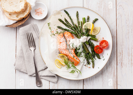 Gegrillter Lachs mit Spargel auf weißem Holz Hintergrund Stockfoto