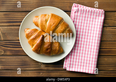 Draufsicht der Croissants auf Teller und karierte Serviette Stockfoto