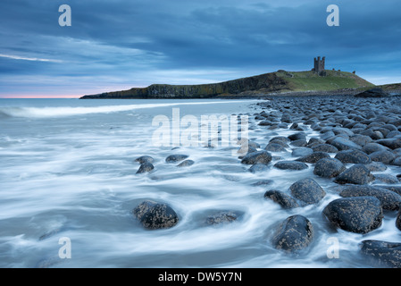 Die Ruinen von Dunstanburgh Castle mit Blick auf den Felsen verstreut Küste von Embleton Bay, Northumberland, England. Stockfoto