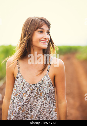 Wunderschöne Mädchen zu Fuß im Feld. Glückliche, unbeschwerte Sommer Lebensstil. Frau mit stilvollen Sonnenkleid. Stockfoto