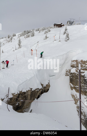 Skifahrer stehen am Rande Corbets Couloir, Jackson Hole, WY Stockfoto