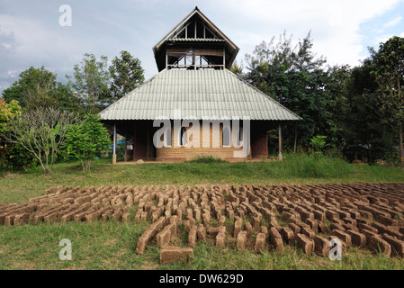 Sonnengetrockneten Lehmziegeln Aushärtung außerhalb einer Adobe-Haus auf dem Pun Pun Bauernhof im Norden Thailands. Stockfoto