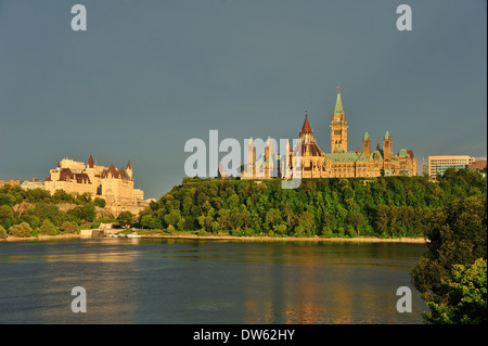 Das kanadische Parlamentsgebäude, gegen einen stürmischen Himmel. Der Ottawa-Fluss im Vordergrund. Stockfoto