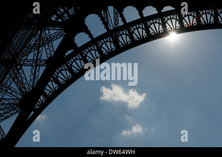 Sonne, die durch den Bogen des Eiffelturms Stockfoto