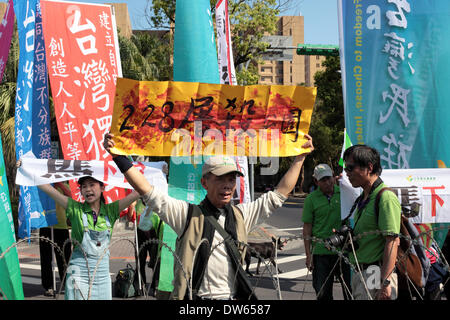 Taipei, Taiwan - 28. Februar 2014: mit Präsident Ma Ying-Jeou liefert seine Rede bei der 228 Memorial Park, Demonstranten für Unabhängigkeit Taiwans, die verspottet sollte der Ort als "228 Schlachtung Park" während der Jahrestag des Massakers 1947 umbenannt werden denen Tausende von nationalistischen Kuomintang-Truppen aus China, an der Taipei Peace Park am 28. Februar 2014 getötet wurden. Das Massaker blieb für Jahrzehnte unter der späten nationalistischen KMT Führer Chiang Kai-shek der Regel Tabu. Es war nicht bis 1995, dass die damaligen Präsidenten Lee Teng-Hui die erste offizielle Entschuldigung gemacht. Stockfoto