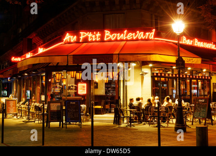 Ein hell erleuchteter Café in Paris bei Nacht Stockfoto