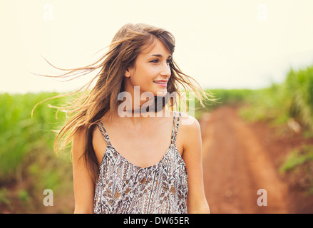 Wunderschöne romantische Mädchen im Freien. Schönes Modell in kurzen Kleid im Feld. Lange Haare im Wind wehen. Hintergrundbeleuchtung, warme Farbe Ton Stockfoto