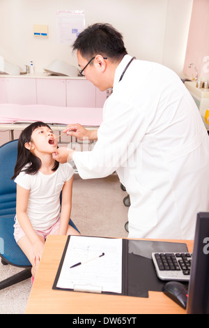 Kinderarzt untersucht Kind Kehle mit Zunge Depressor in Klinik Stockfoto
