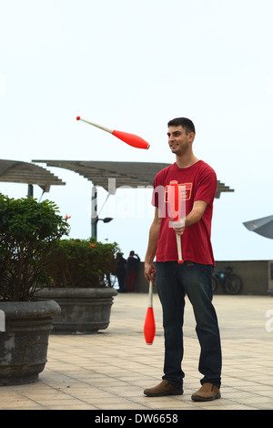 Junger Mann Jonglieren mit drei Clubs in Larcomar im Stadtteil Miraflores in Lima, Peru Stockfoto