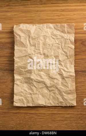 zerknitterte Papier auf Holz Hintergrund Stockfoto