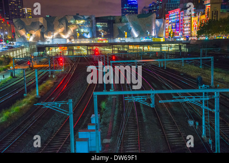 Trainieren Sie auf Bahngleisen führt in Melbourne unterirdische Bahnhof Flinders Street Station mit dem Zug auf Schienen Skyline der Stadt Stockfoto