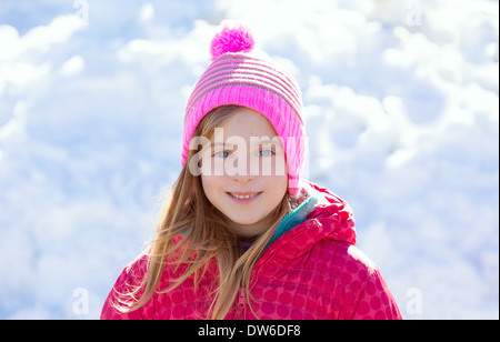 Blonde junge Mädchen Rosa Wintermütze im Schnee glücklich lächelnd Stockfoto