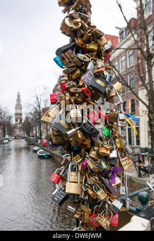 Liebesschlösser angebracht zu einer Brücke über einen Kanal, Amsterdam, Niederlande Stockfoto