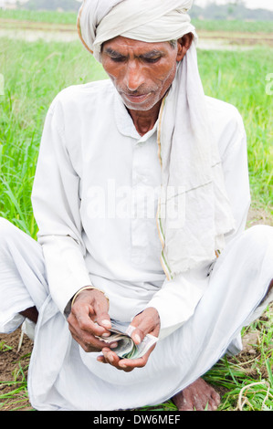 1 indische Bauern sitzen und zählen Rupien Stockfoto