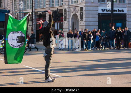 London, 1. März 2014. London März gegen die staatliche Korruption. Im Bild: Ein Aktivist zeichnet in der Straße am Piccadilly Circus Demonstranten gegen die staatliche Korruption marschieren. Bildnachweis: Paul Davey/Alamy Live-Nachrichten Stockfoto