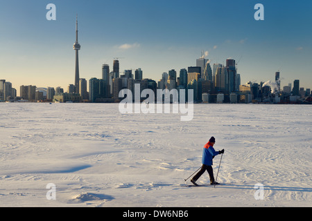 Langlauf auf gefrorenen See Ontario mit Skyline von Toronto im Winter aus Toronto Islands Kanada Mann Stockfoto