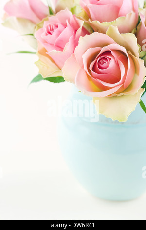 Rosa Rosen in einer leichten blauen Vase auf Creme Beige shabby chic Hintergrund mit Textfreiraum Stockfoto