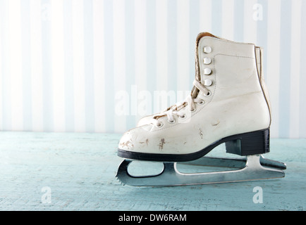 Paar weiße Frauen Schlittschuhe auf blauen Vintage Holz-Hintergrund - feminine Wintersport-Konzept Stockfoto