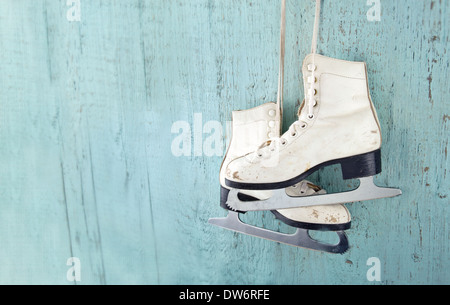 Paar weiße Frauen Schlittschuhe auf blauen Vintage Holz-Hintergrund - feminine Wintersport-Konzept Stockfoto