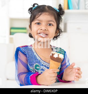 Eis essen. Niedlichen indische Asiatin ein Eis zu genießen. Schönes Kind Modell zu Hause. Stockfoto