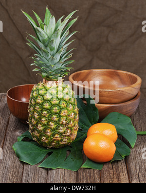 Stilleben mit Ananas und Orangen auf Holztisch. Closeup. Stockfoto