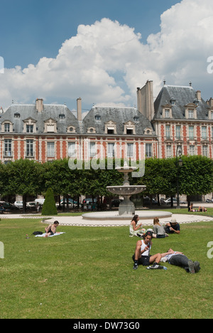 Menschen-Picknick auf dem Rasen in der Place des Voges in Paris, Frankreich. Stockfoto