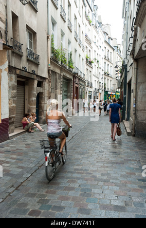 Eine Mädchen fährt Fahrrad entlang der Rue de Rivoli im Viertel Le Marais in Paris, Frankreich. Stockfoto