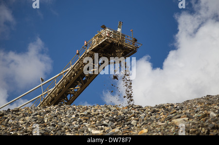 Material fällt aus einem Förderband auf einer Halde in einen großen Topf und Goldmine in Afrika Stockfoto