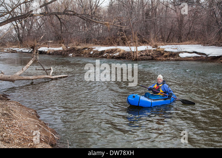 Senioren männlich ein Packraft (ein-Personen-leichte Floß zur Expedition oder Adventure racing) auf dem Cache La Poudre River paddeln Stockfoto