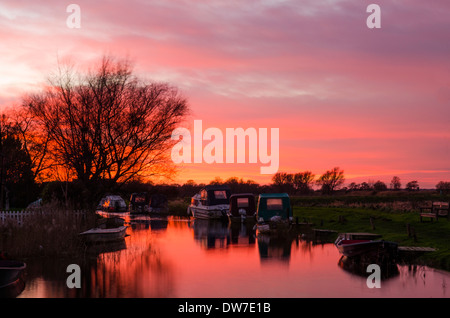 Der Kanal am West Somerton führt in Richtung Martham breit. Die Norfolk Broads, UK. Sonnenuntergang. Dezember. Stockfoto